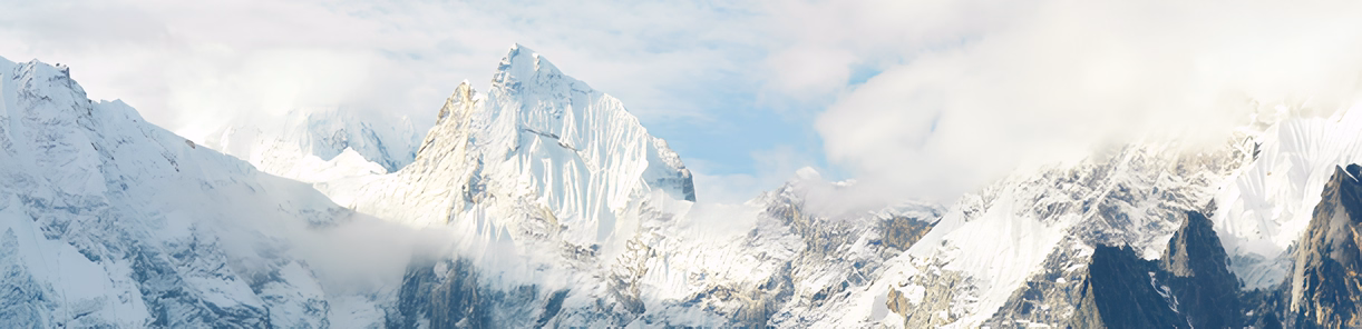 Chaîne de montagnes enneigées himalayennes sous ciel bleu.