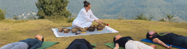 Participants pratiquant le yoga en pleine nature face aux montagnes du Népal