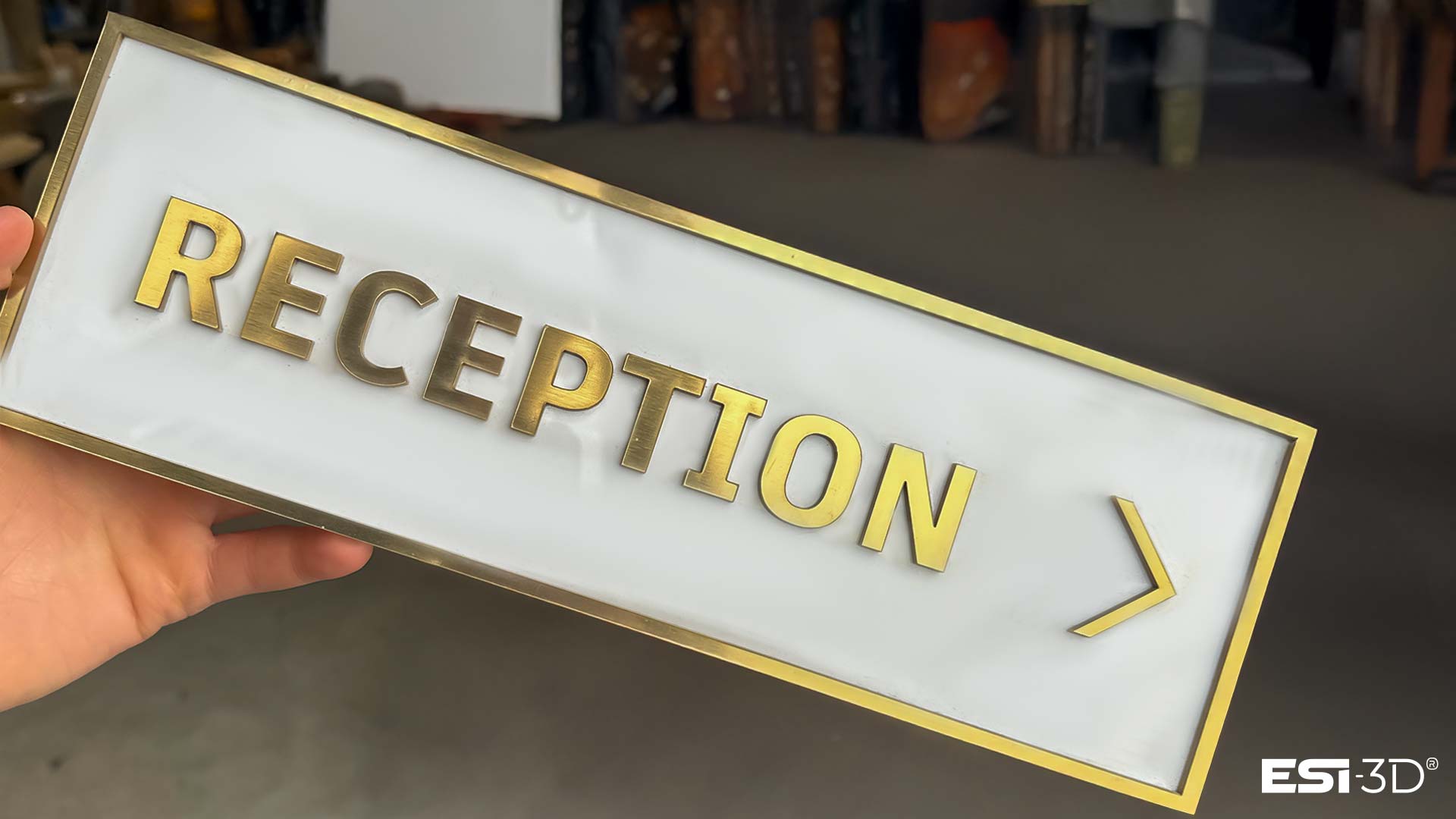 Panneau directionnel en PMMA effet or brossé et laiton marqué réception, découpé au laser CO2 et assemblé par collage, conçu pour la signalétique haut de gamme d’un hôtel de luxe