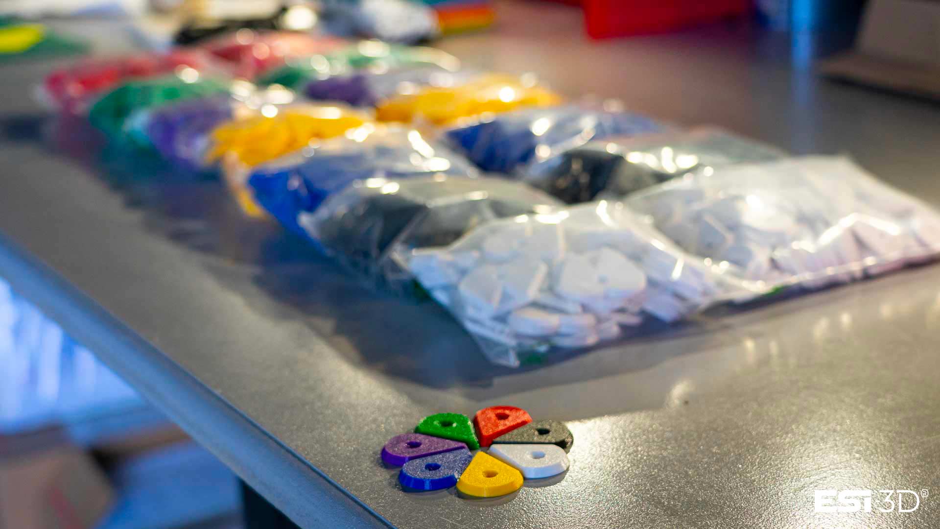 Pièces directionnelles pour mur d’escalade produites en série par impression 3D FDM, visibles en vrac dans des sacs