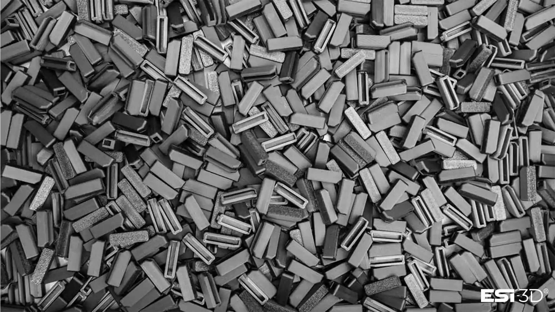 Petits taquets techniques fabriqués en série par impression 3D pour un spécialiste de l’agencement de magasins, présentés en vrac dans un bac