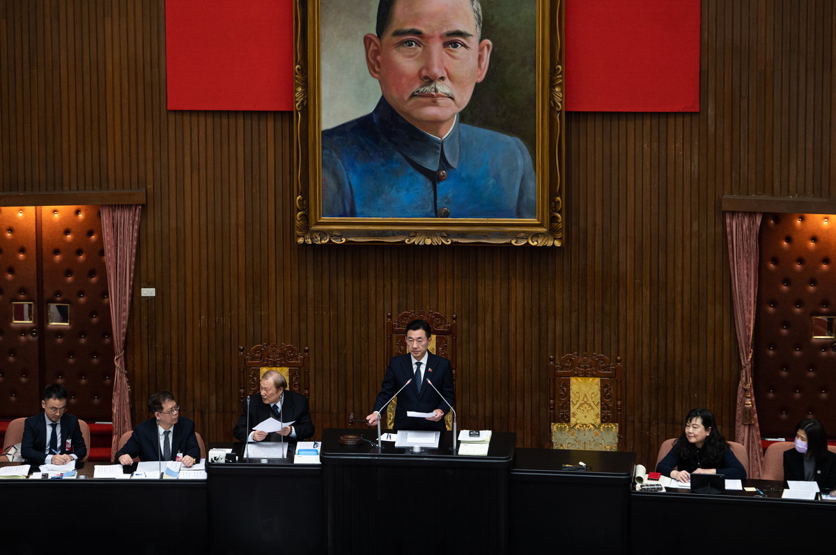 政府官員坐在正式的會議廳內。