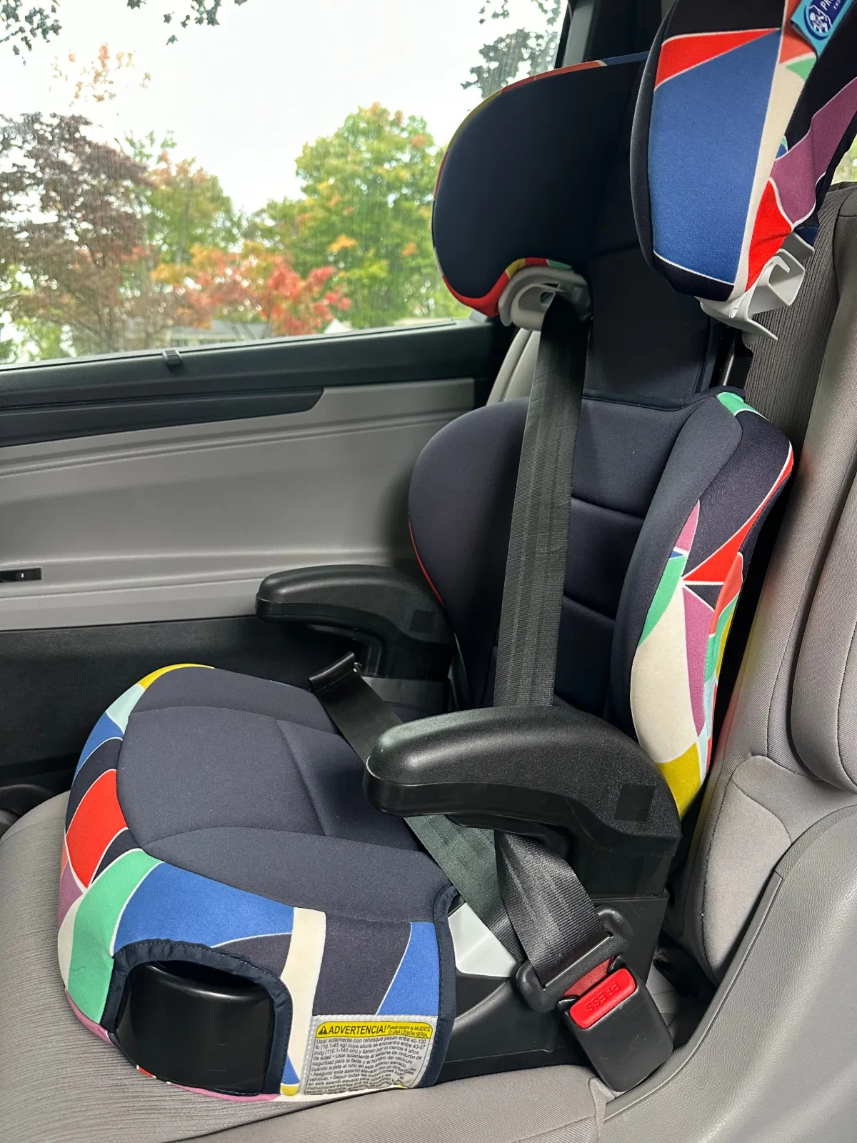 Empty Graco TurboBooster 2.0 with the vehicle seat belt buckled across it