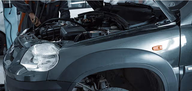Mechanic checking car engine in auto repair shop