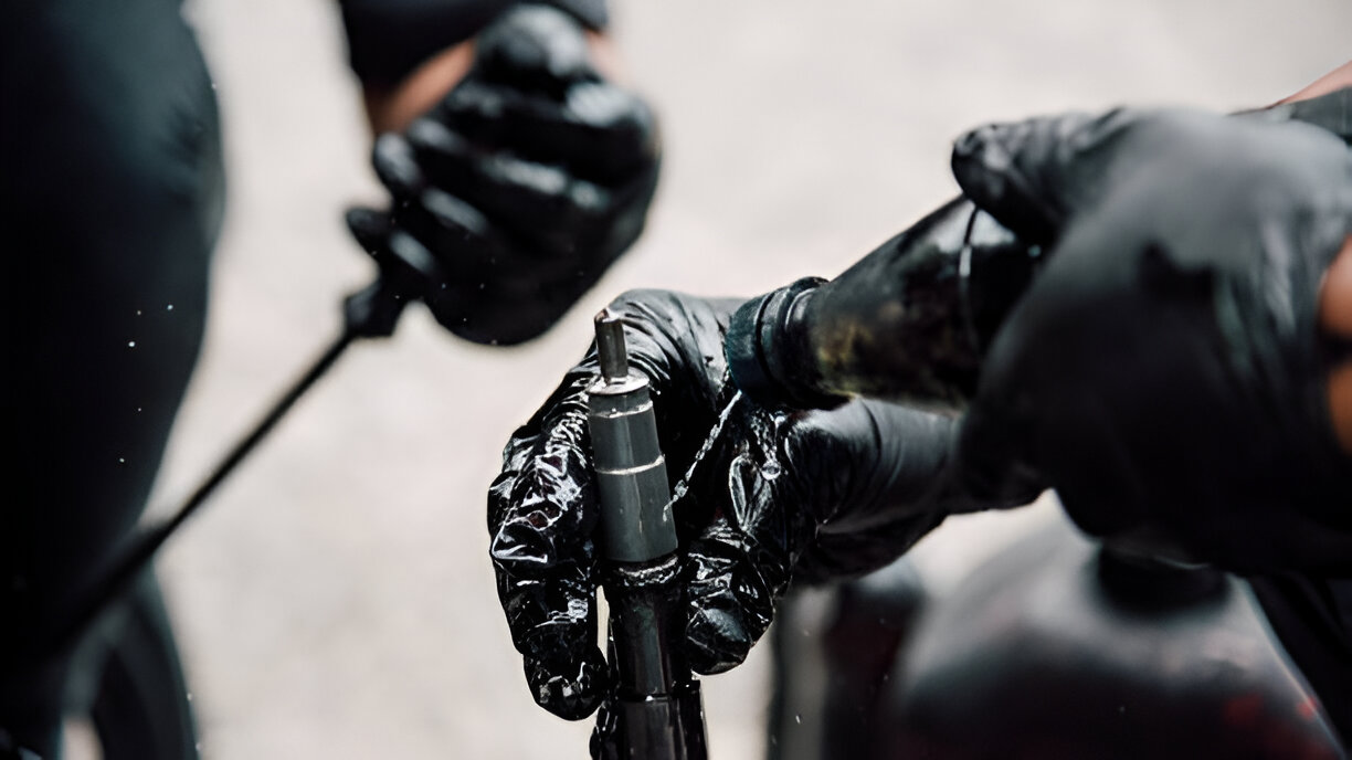 Hands in black gloves working on a mechanical or technical component
