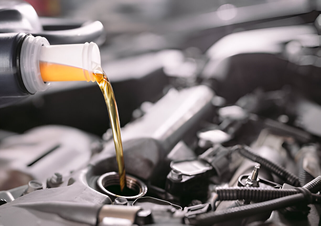Pouring golden motor oil into car engine during maintenance