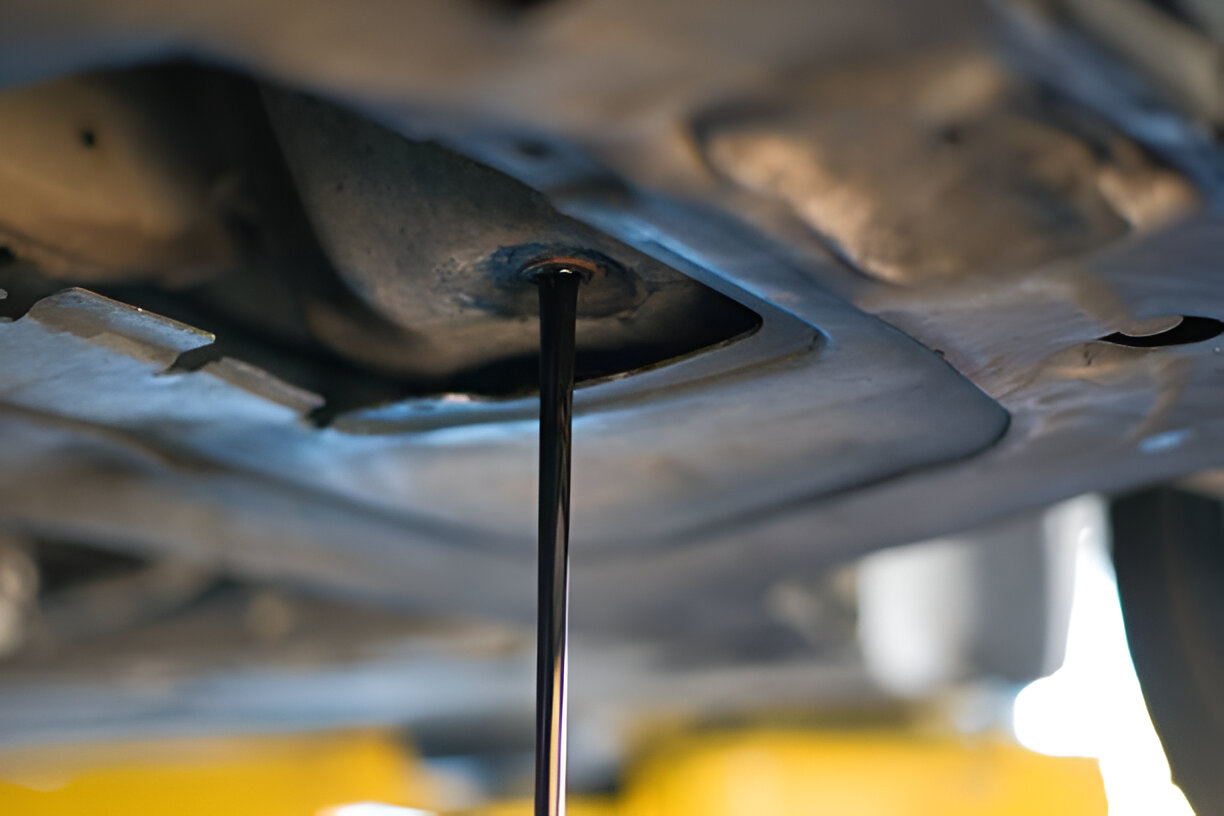 Close-up of car undercarriage with thin metal rod or dipstick