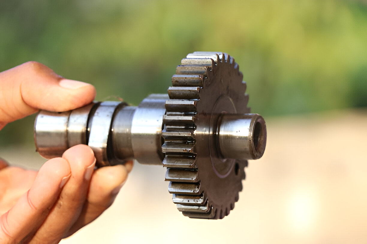 Metal gear mechanism held by hand, showing intricate mechanical engineering details