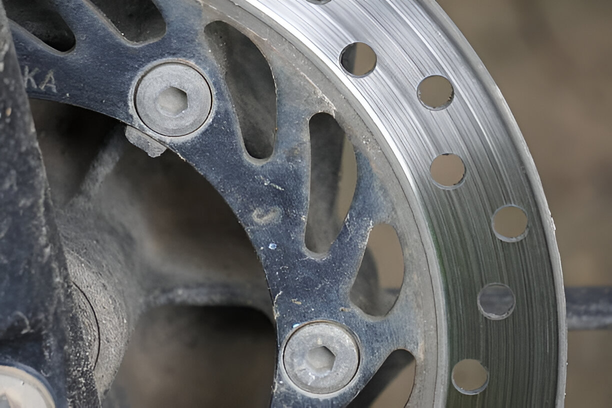 Close-up of a metal wheel with bolts and perforated circular design