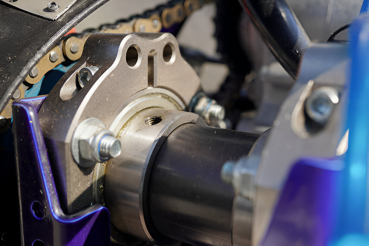 Close-up of motorcycle engine component with chain and metallic parts