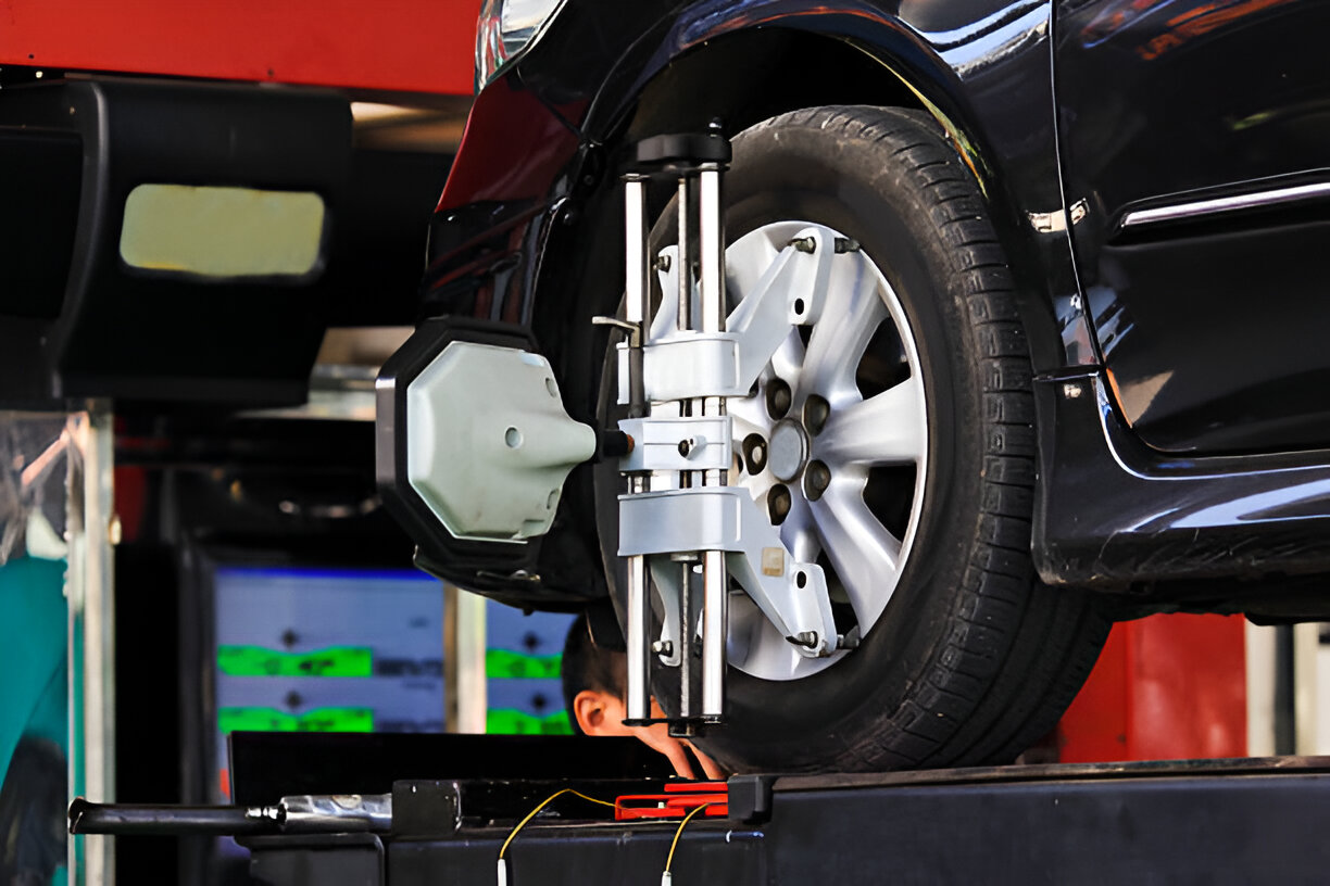 Car wheel aligned on precision machine in automotive repair shop