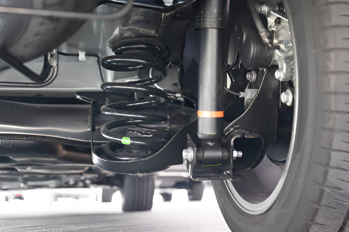 Close-up of car suspension system with black coil springs and shock absorber