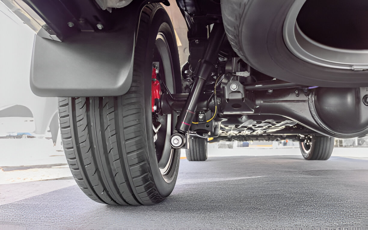 Close-up of vehicle wheel and suspension system on concrete floor