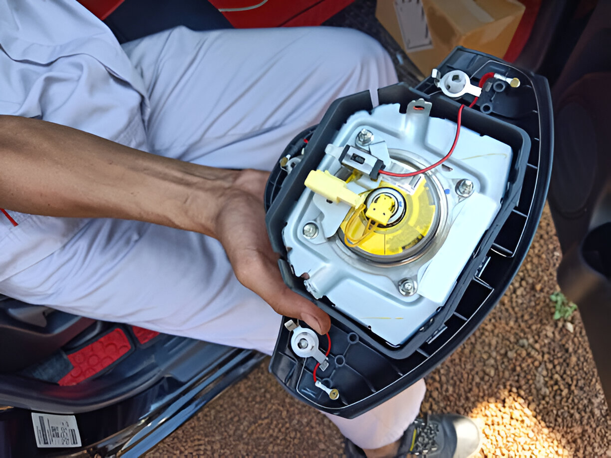 Disassembled car part showing internal electronic and mechanical components