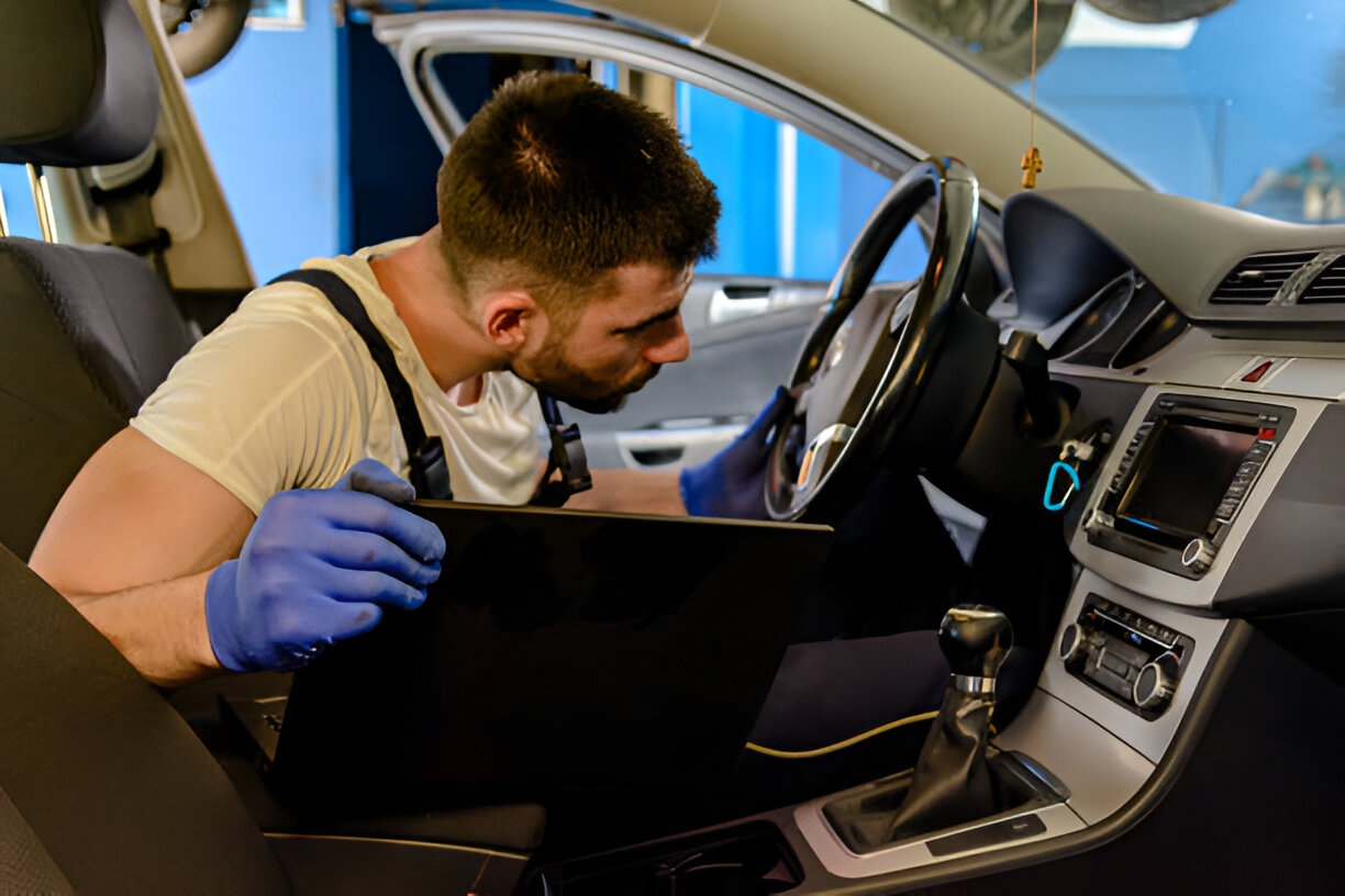 Mechanic in blue gloves inspecting car interior during maintenance