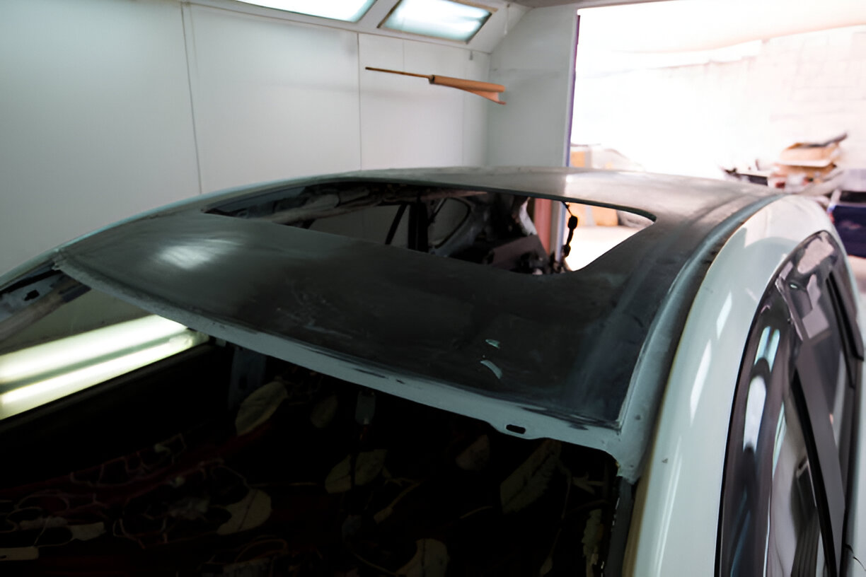 Car with damaged roof in auto body repair shop workshop