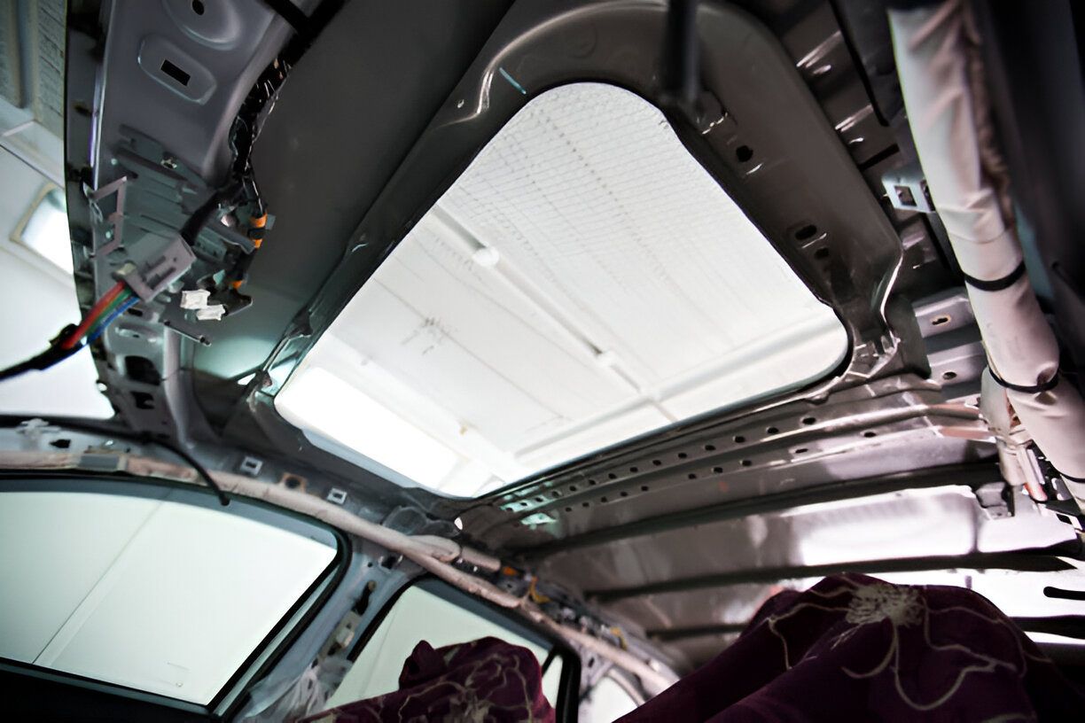 Car interior showing sunroof and complex mechanical roof structure