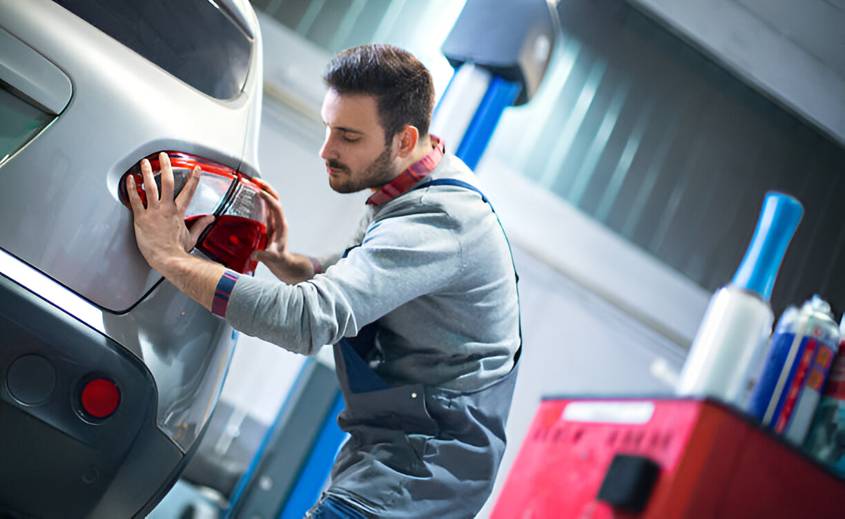Car service worker refilling windshield washer fluid at auto repair shop