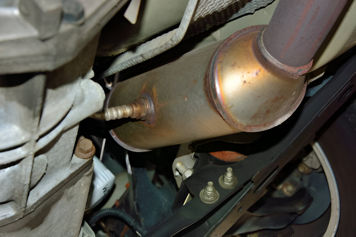 Closeup of a car's catalytic converter and exhaust system components