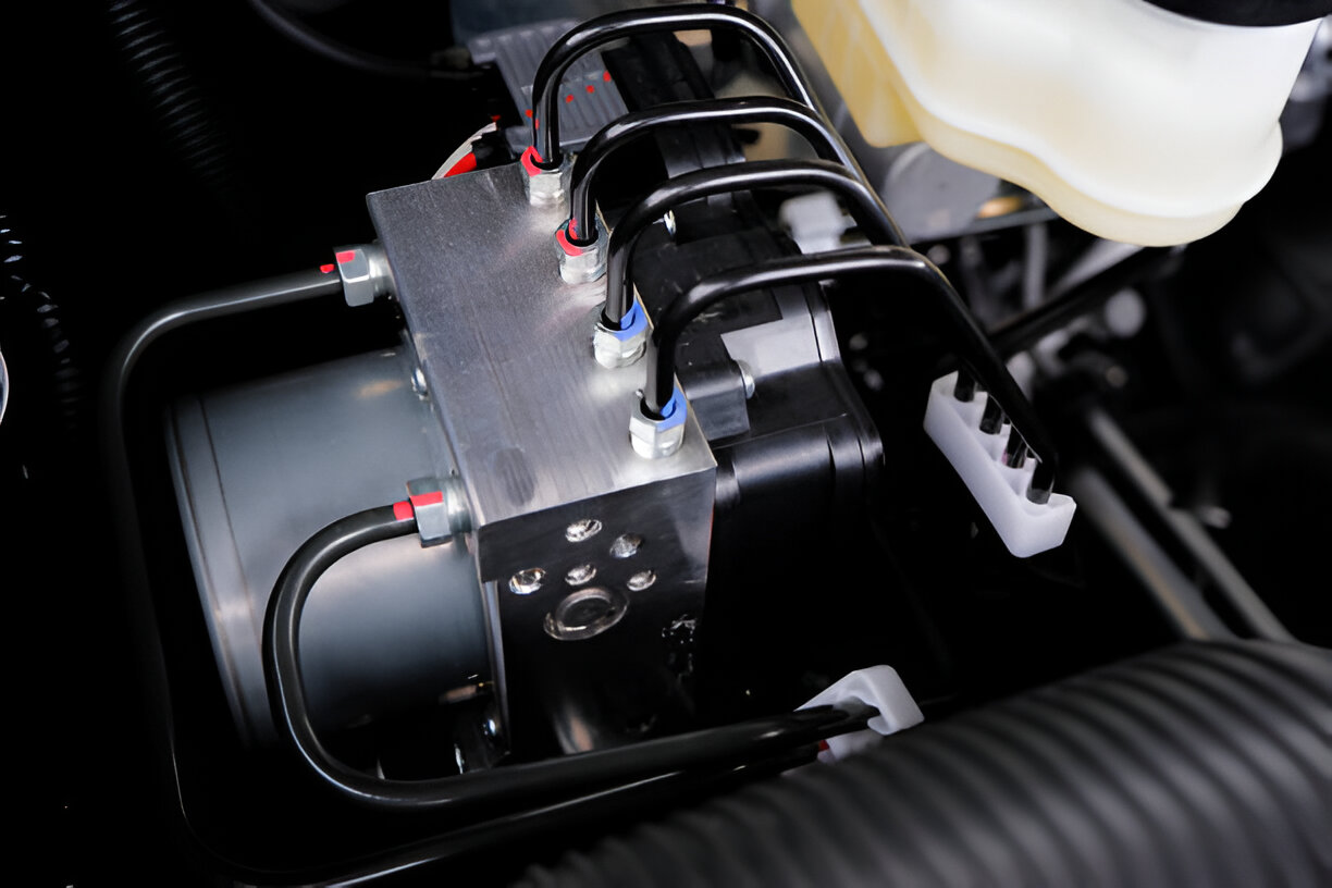 Close-up of hydraulic valve block with electrical connections and tubes