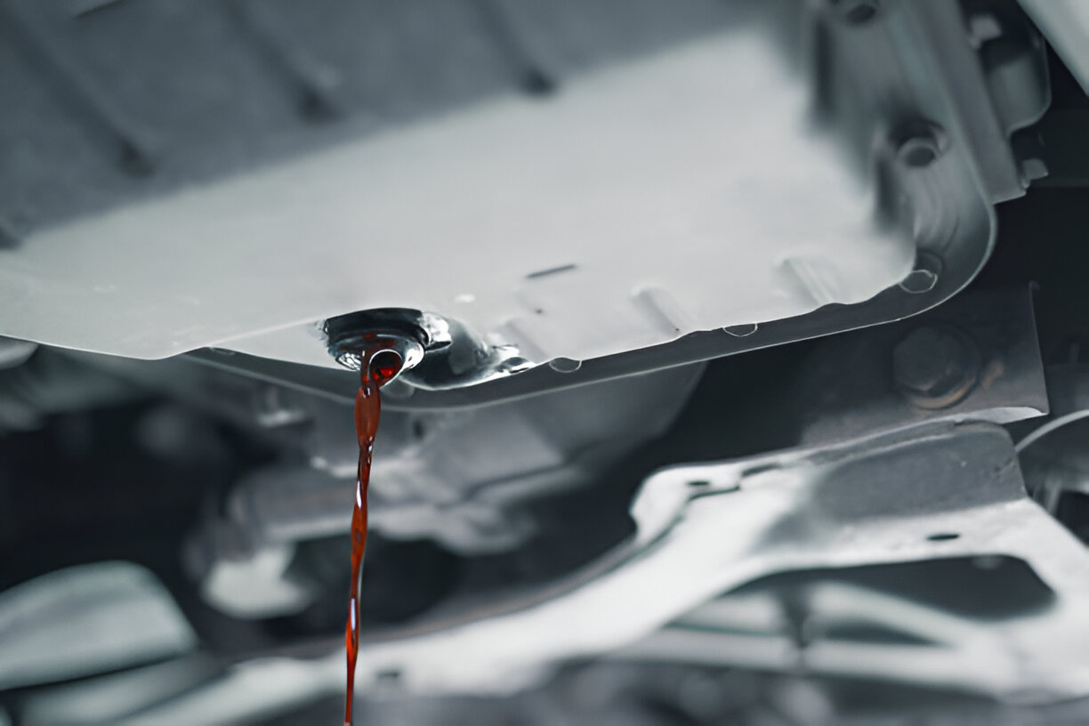 Red liquid dripping from mechanical component in monochrome close-up