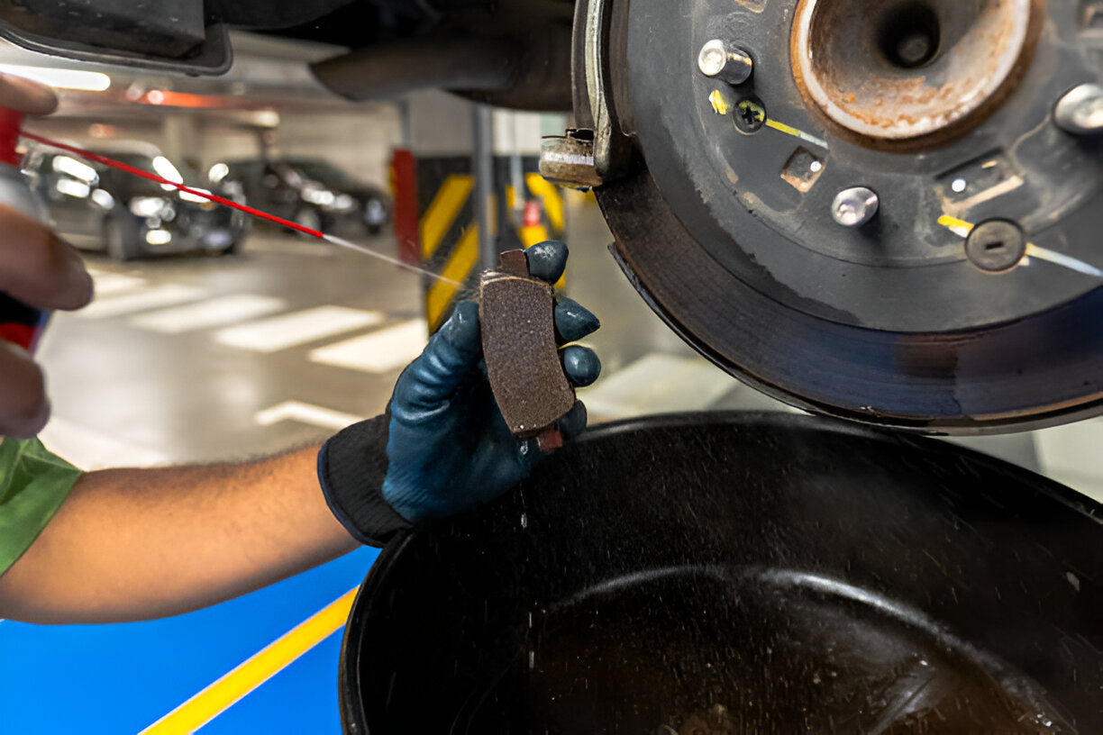 Mechanic replacing brake pad on vehicle disc brake system