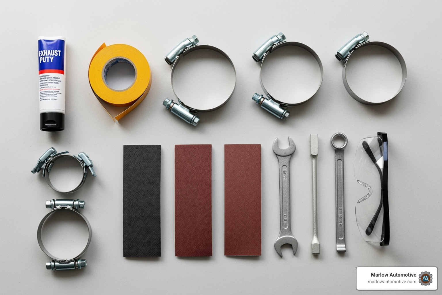 Tools and materials laid out for exhaust repair including putty, tape, clamps, sandpaper, wrench, and safety glasses - car exhaust repair