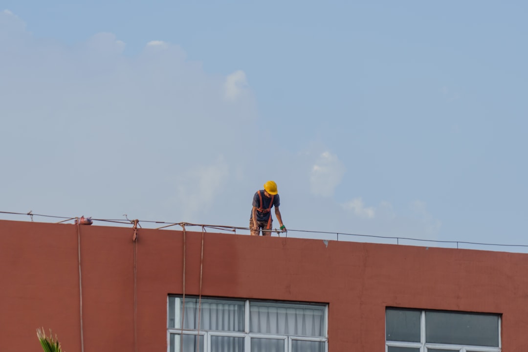 A commercial HVAC technician inspecting a large rooftop unit on a building - commercial hvac repair des moines