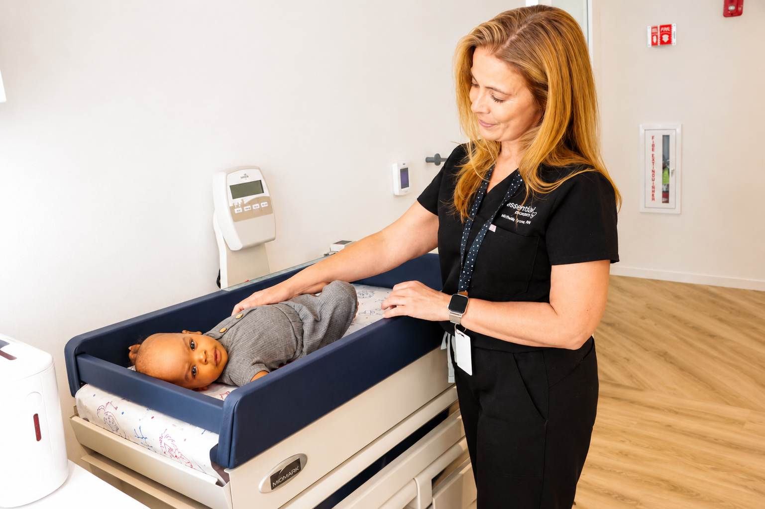 A nurse weighing a baby during a newborn exam