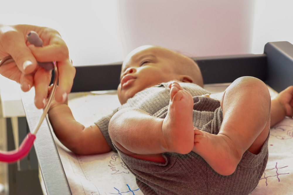 A doctor with a new parent and baby at Essential Pediatrics