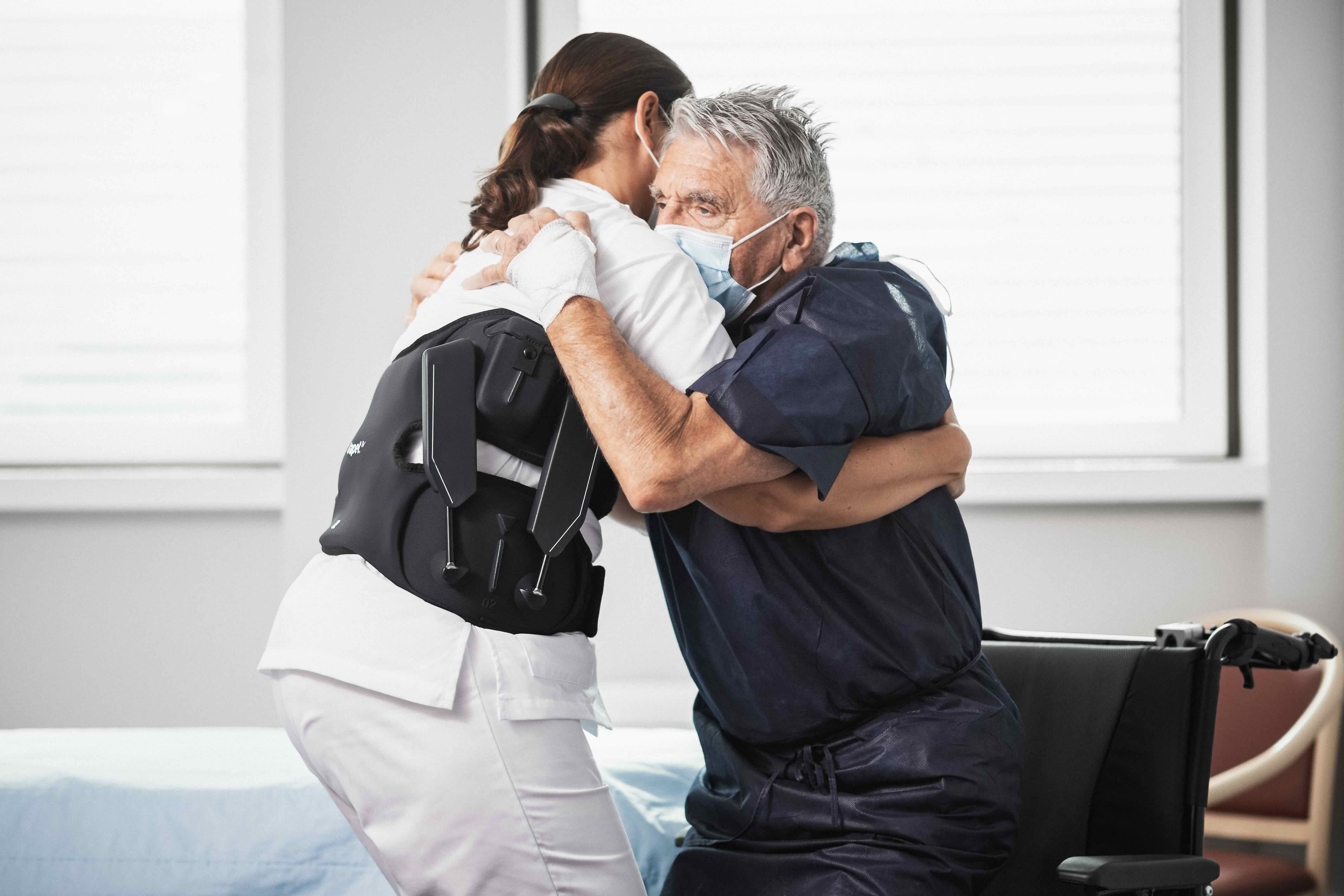 Une infirmiere porte l'exosquelette qui protege le dos
