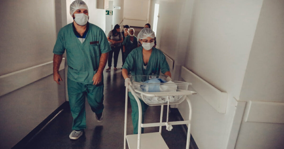 Des infirmiers marchent dans les couloirs d'un hôpital, ils portent des chaussettes anti fatigue et des semelles anti fatigue sous leur tenue de travail