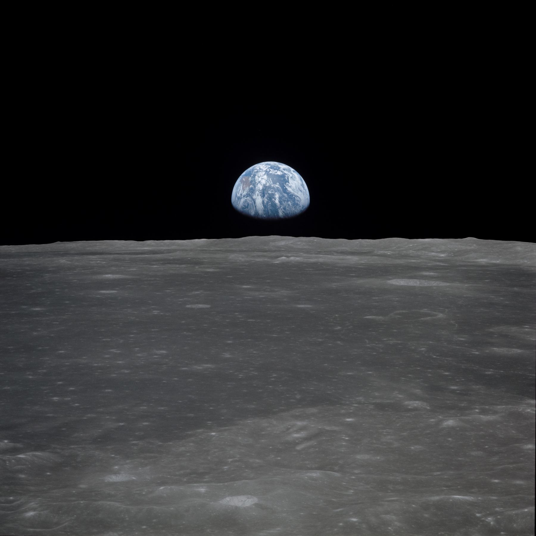 The lunar limb with Earth in the distance, photographed from Apollo 11.