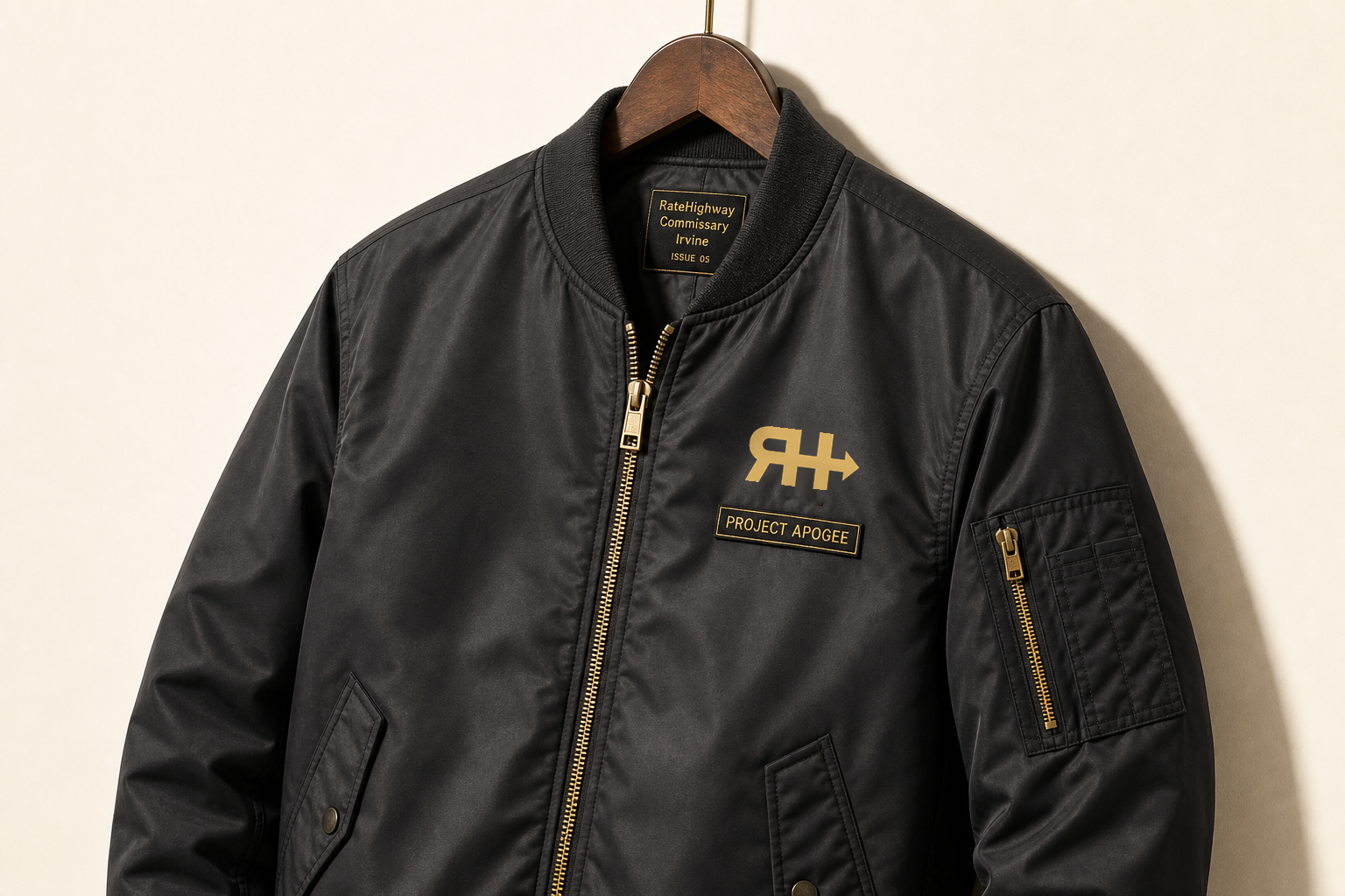 Charcoal flight jacket: official RH at the heart, PROJECT APOGEE plate beneath, gold zipper.