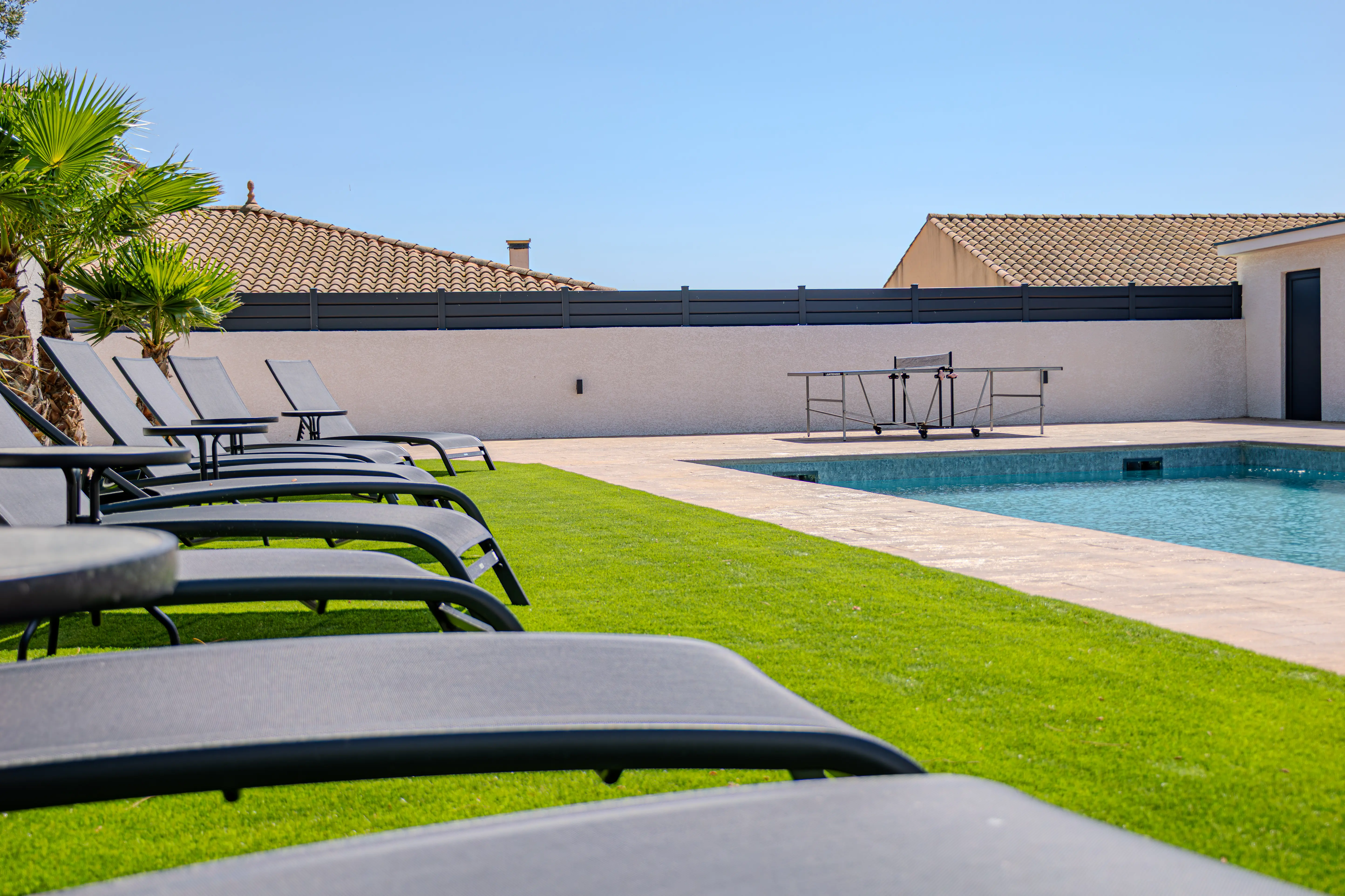 Sun loungers on the left side of the image with the pool of Villa Galinier on the right.