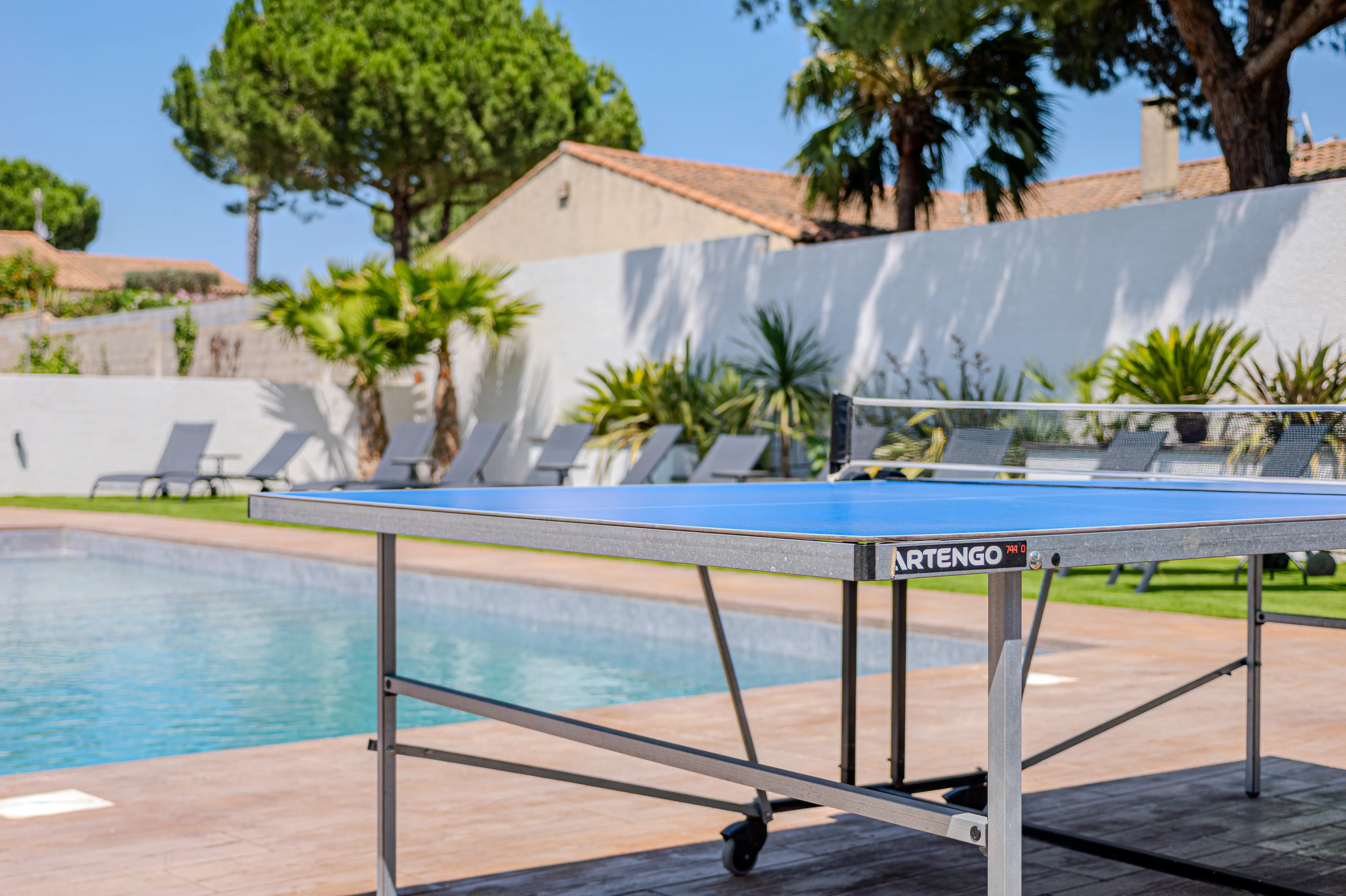 A photograph of the table tennis table with the swimming pool in the background.