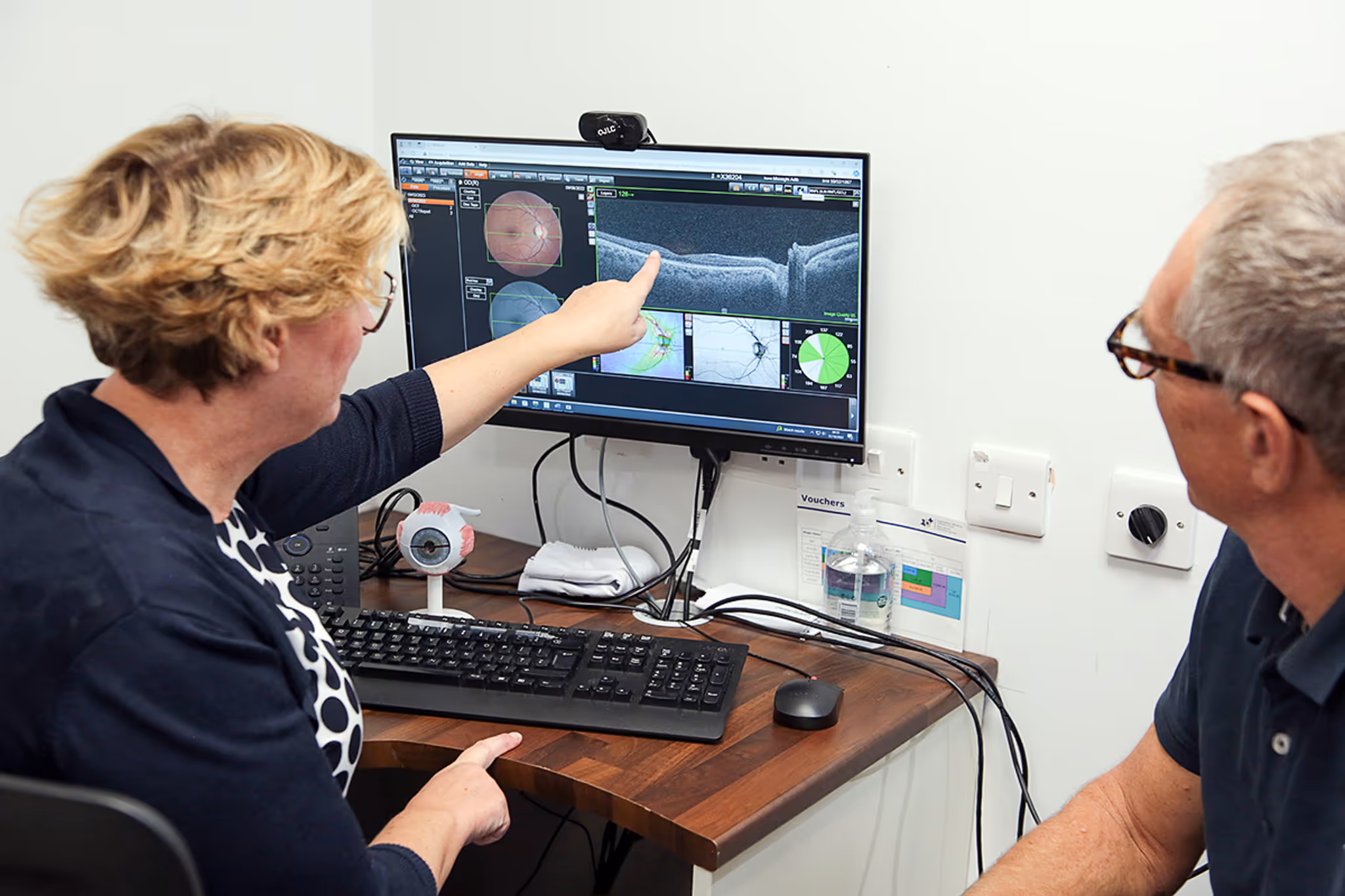 Medical professionals analyzing eye scan images on computer screen