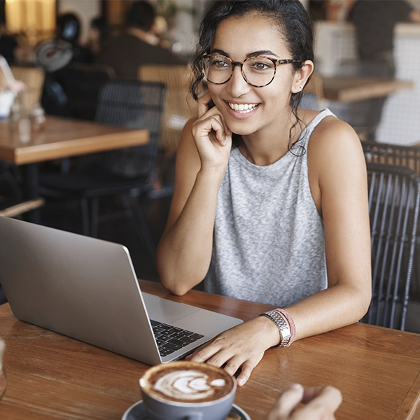 A girl at a coffee shop on her laptop. 