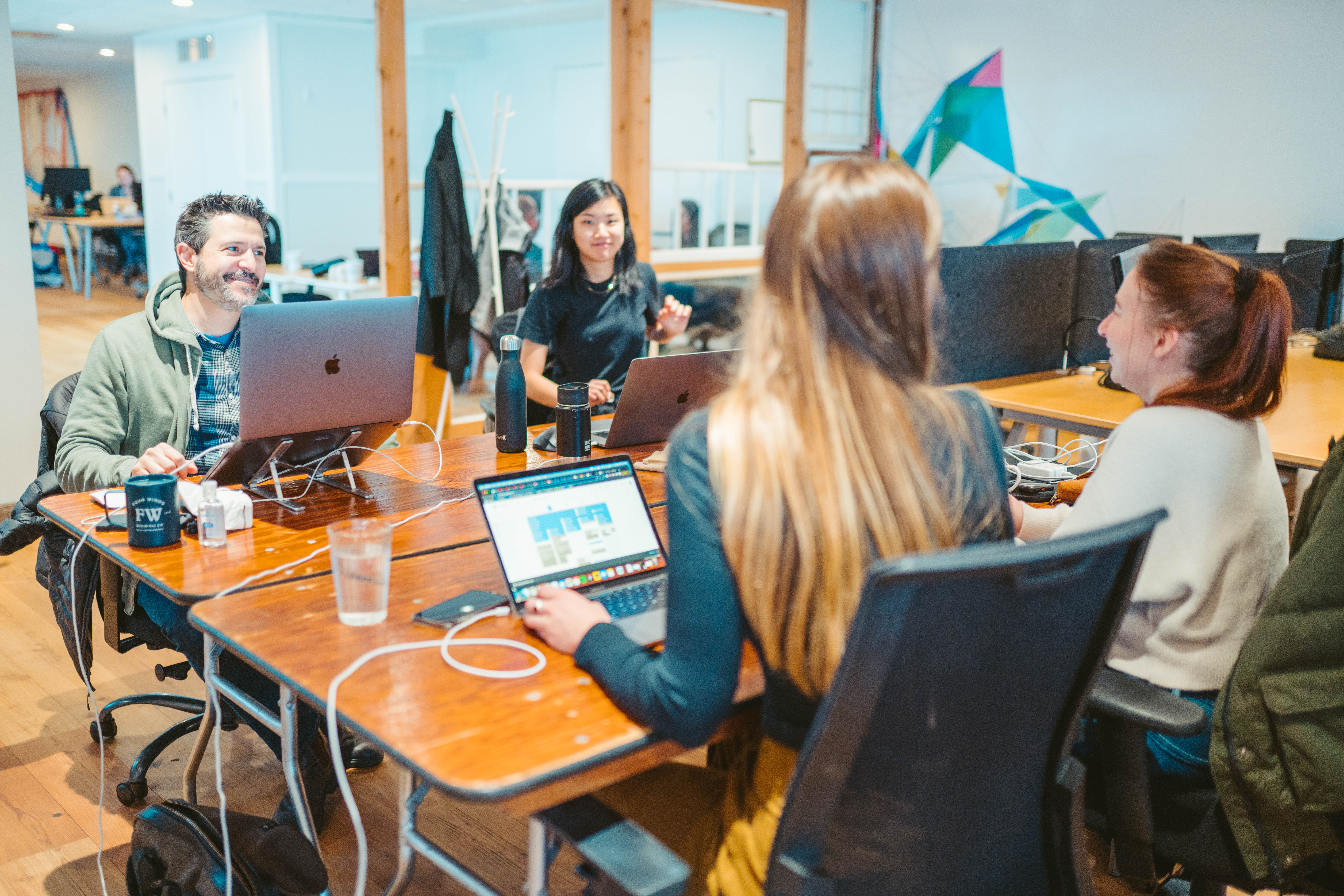 People picking up garbage on the beach and putting it in blue garbage bags.