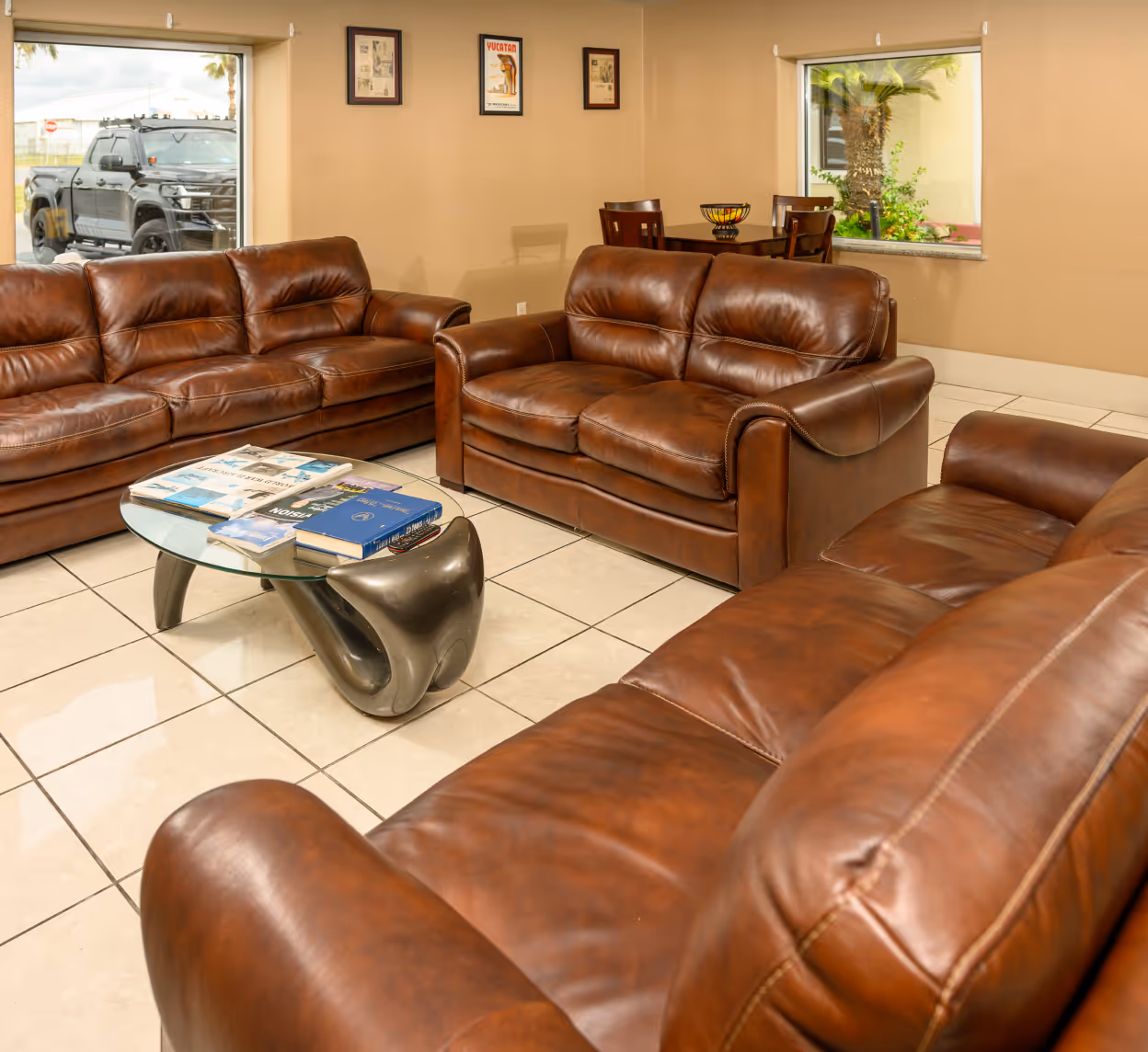 Hunt PanAm lobby with three brown leather couches and a coffee table.