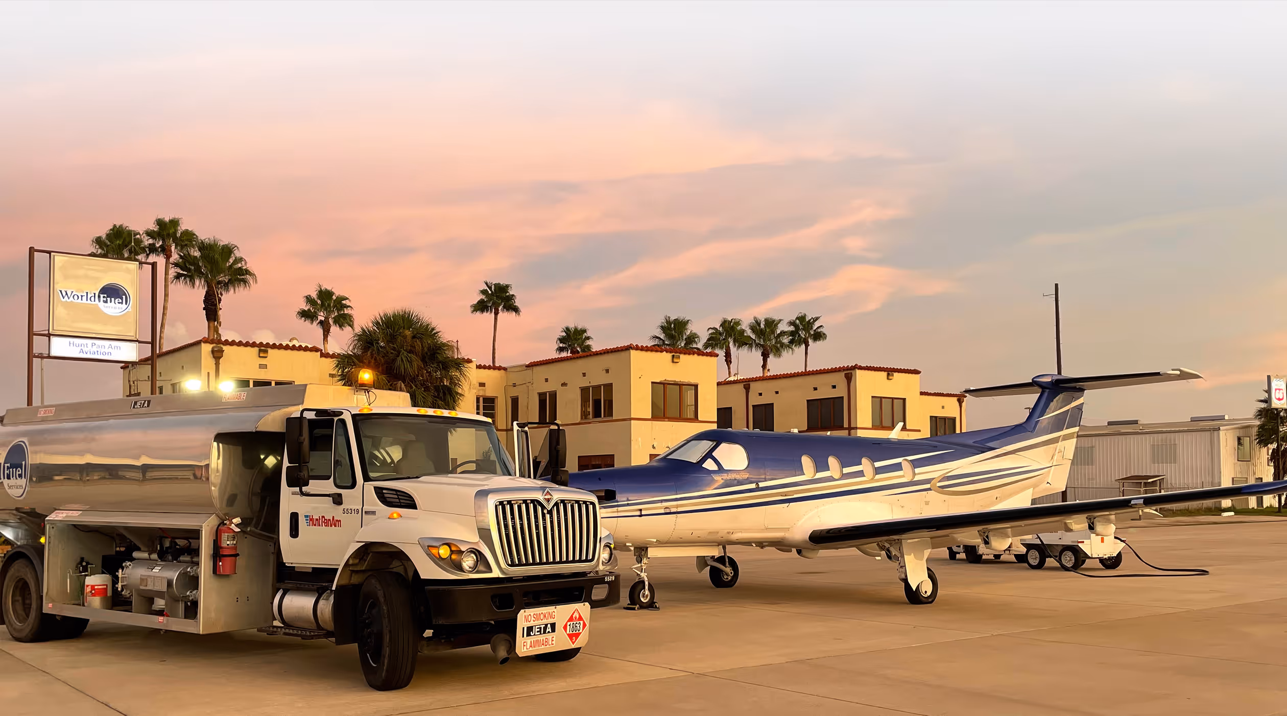 Fuel tank and small aircraft parked on tarmac at Hunt Pan Aviation