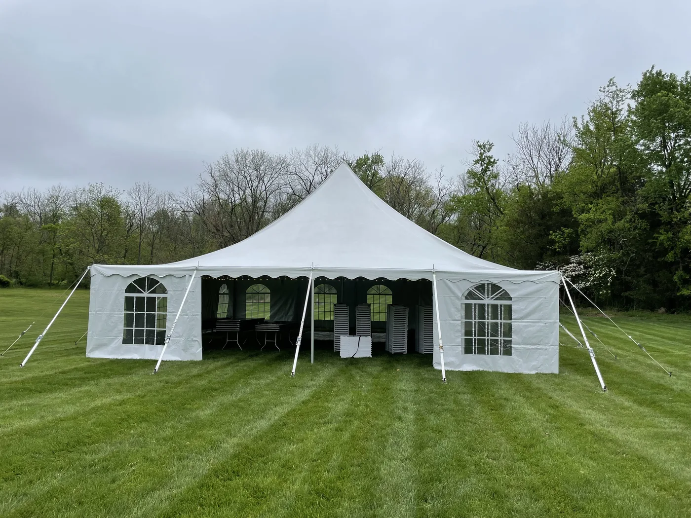 HPR pole tent with windowed sidewalls and a wide open center entrance on a lawn.