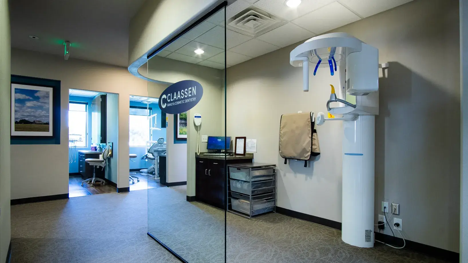 A dentist office workspace with brown cabinets, sterilizer machines, and various dental supplies on counters.