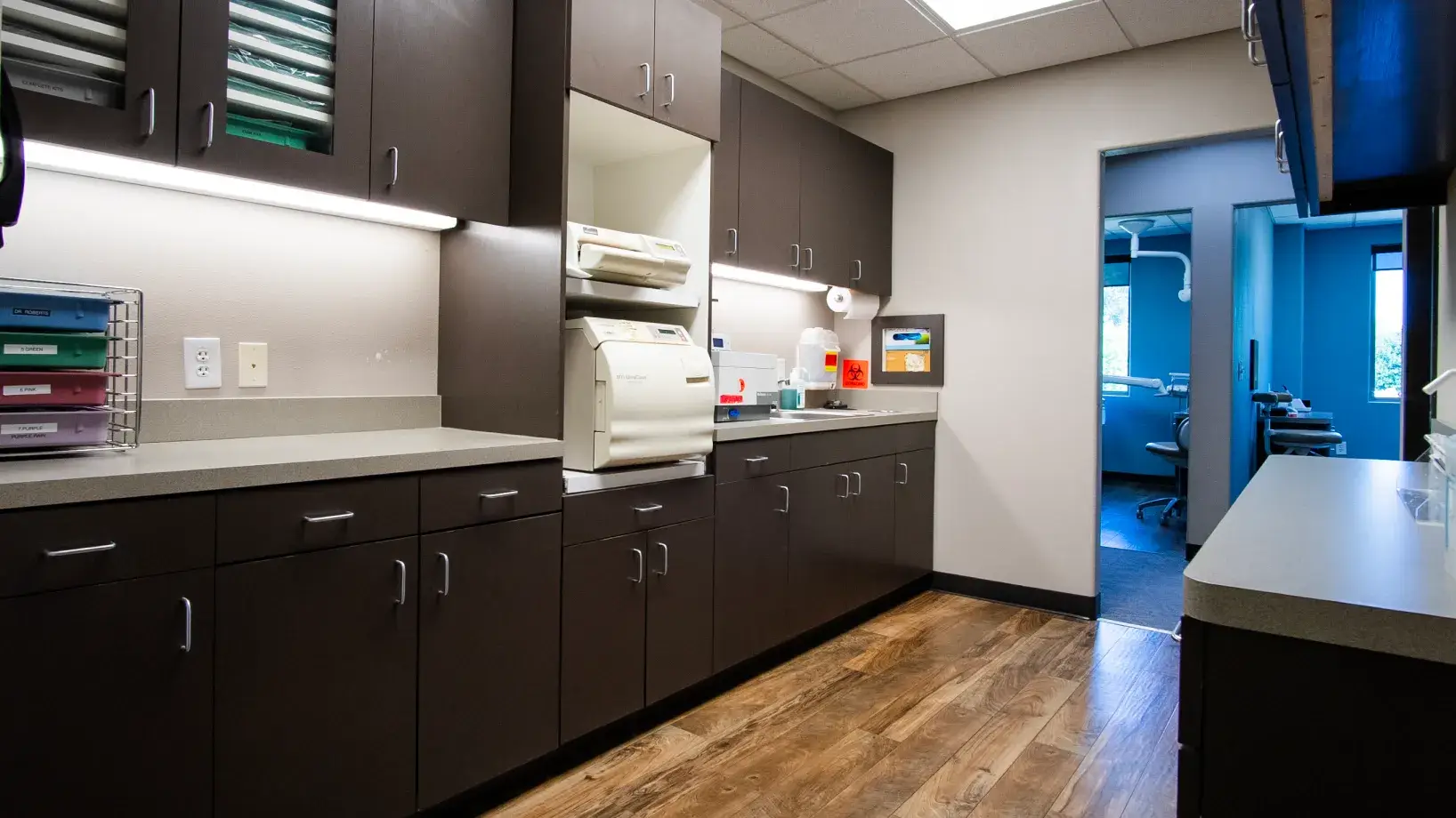 Dental office with an X-ray machine and a chair visible in the exam room.