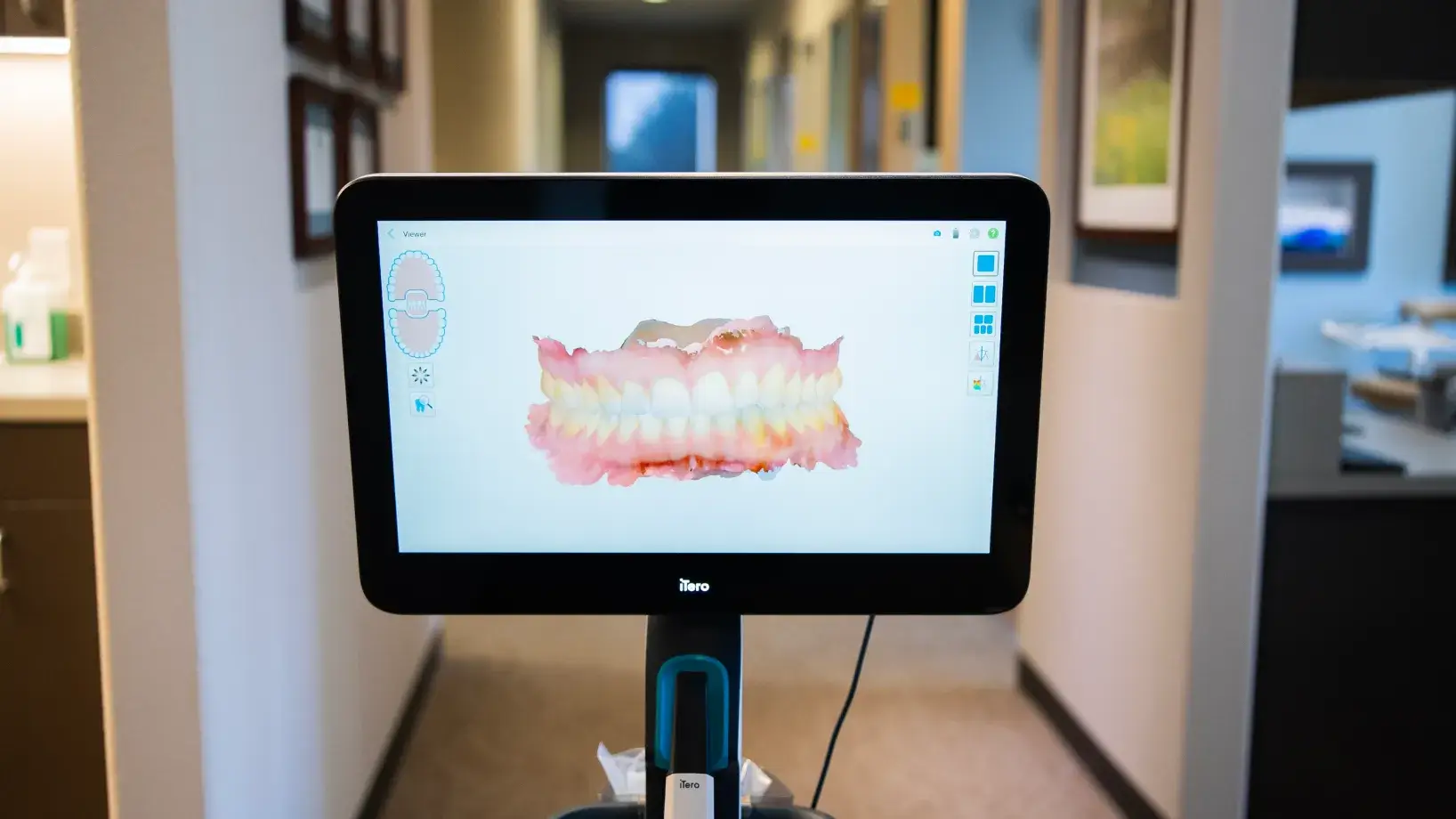 A woman sits in a dental chair, smiling at a dentist who is also smiling back.