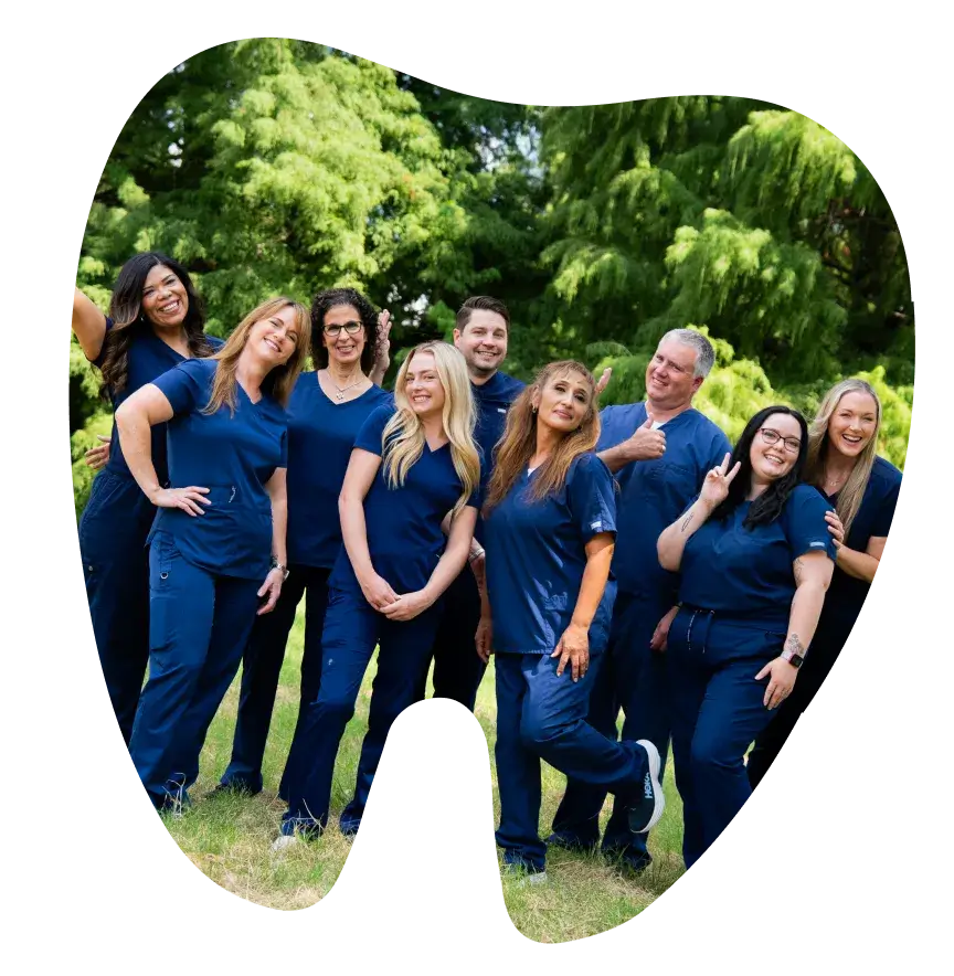 Group of nine people in matching blue outfits smiling and posing outdoors in a tooth-shaped frame.