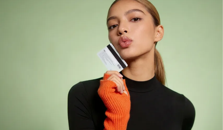 A woman holding a credit card in her hand.