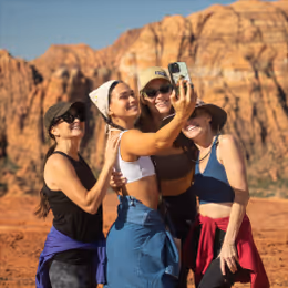A group of women in a desert destination taking a selfie together.