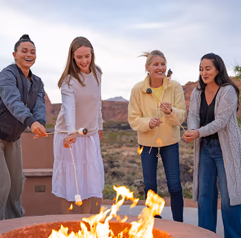 A group of friends around a bonfire roasting marshmallows.