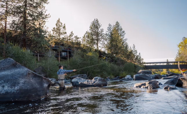 A man fishing in a river at the River House Resort.